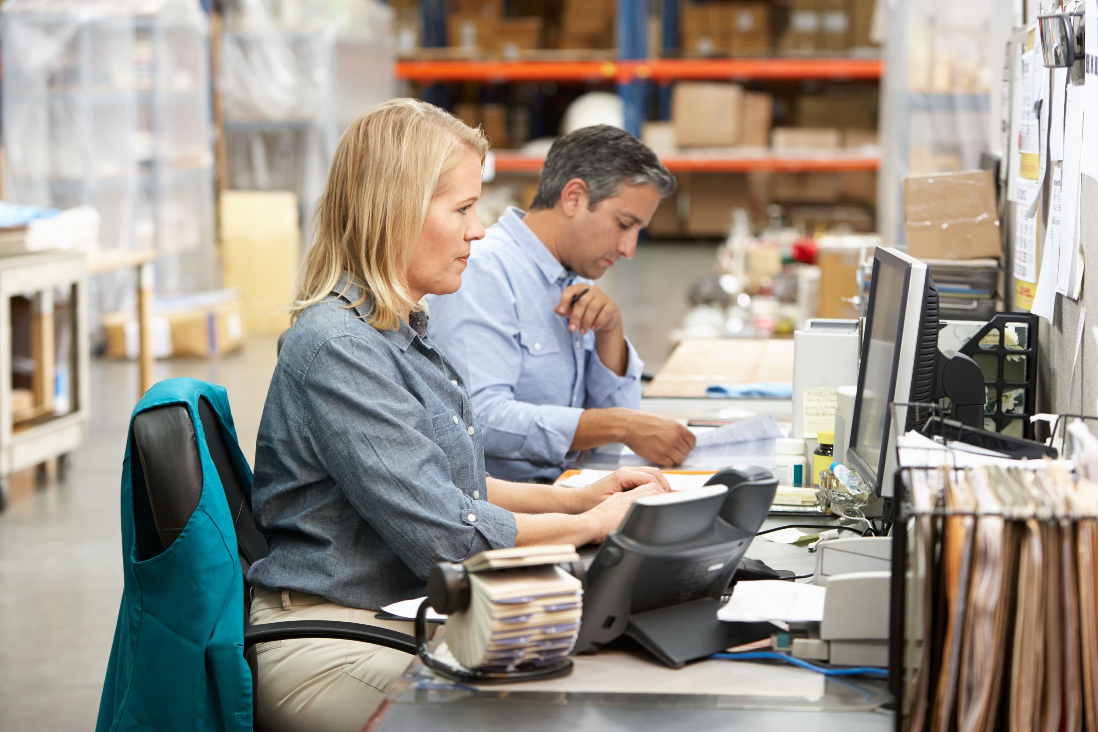 Two people sat at a desk working 