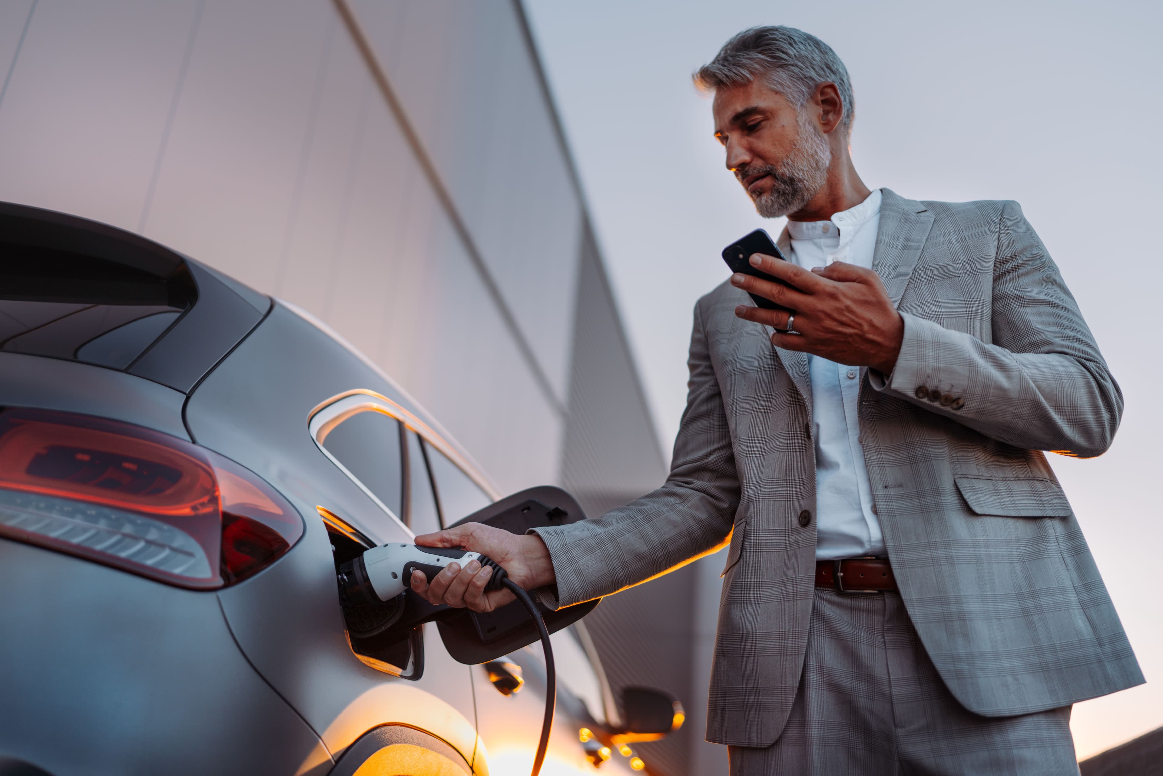 A businessperson putting their electric car on charge