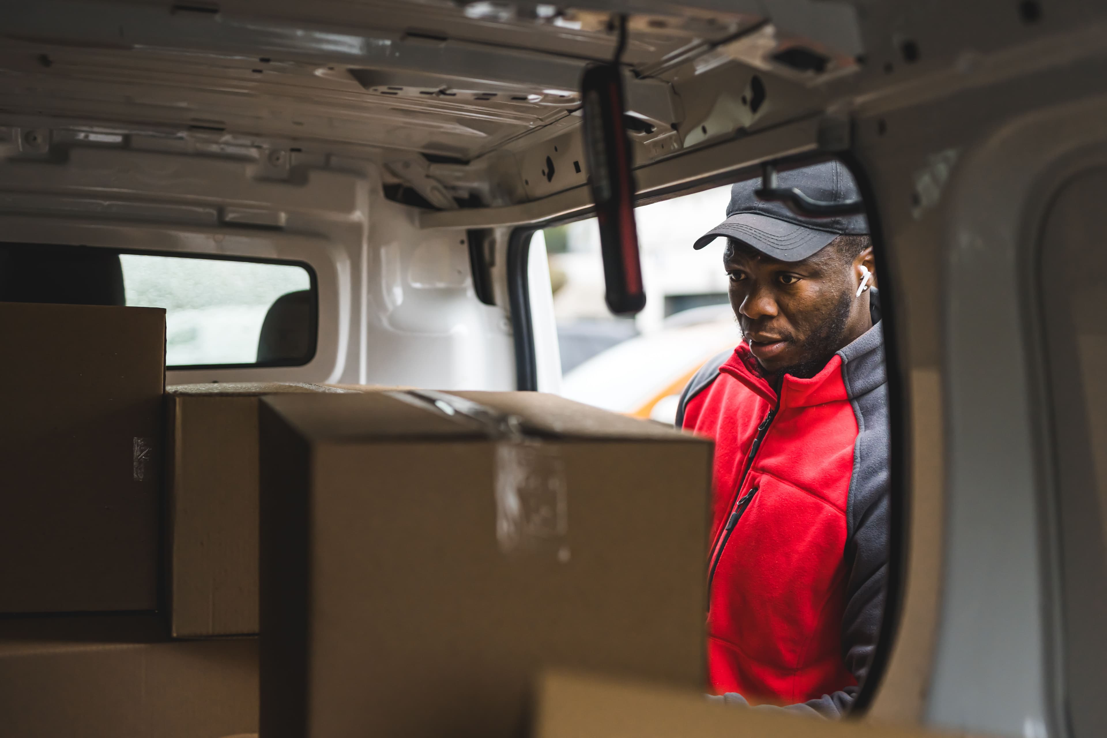 Courier driver looking into their van from the side door 