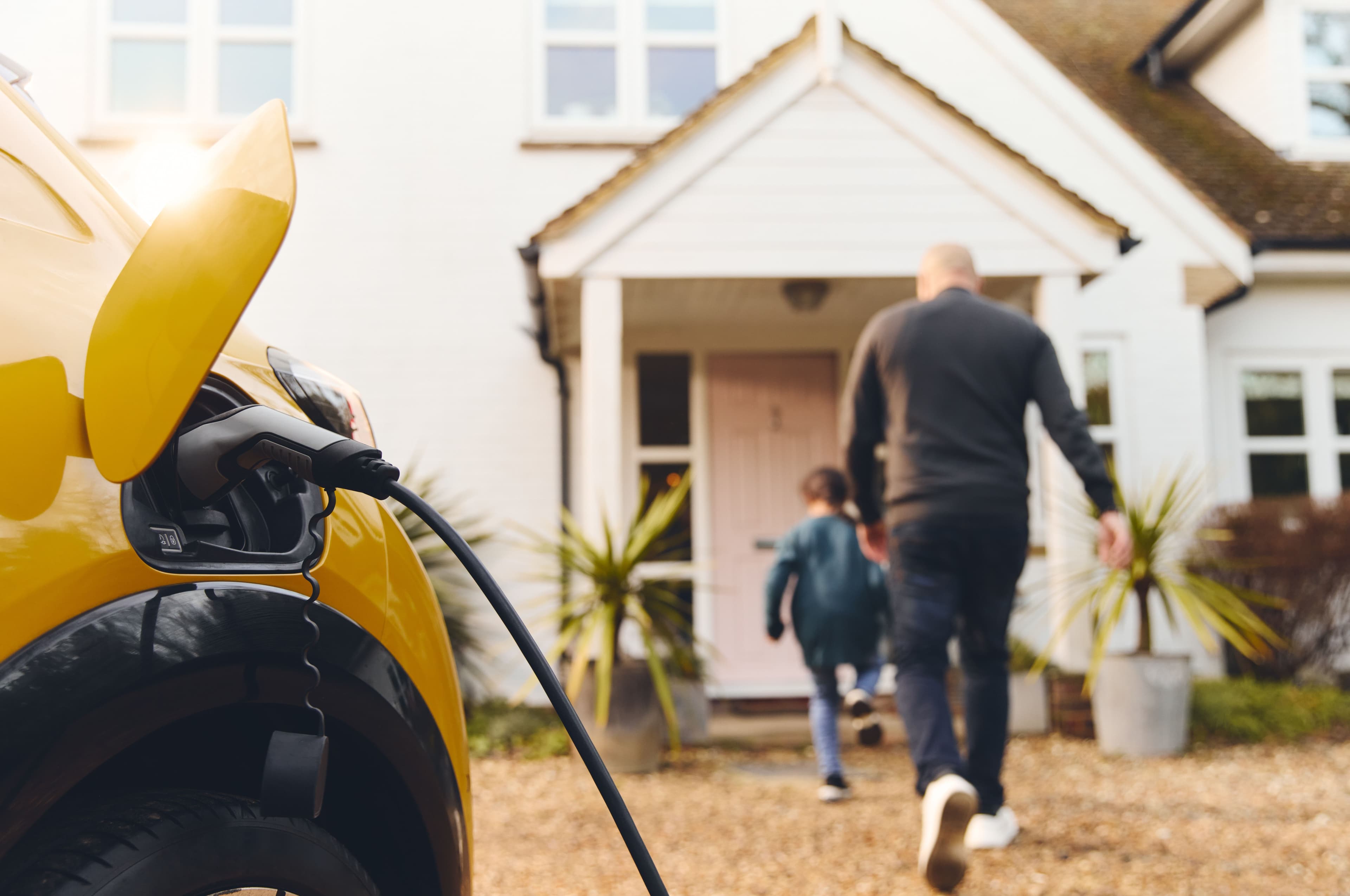 Family walking to their front door whilst EV is on charge