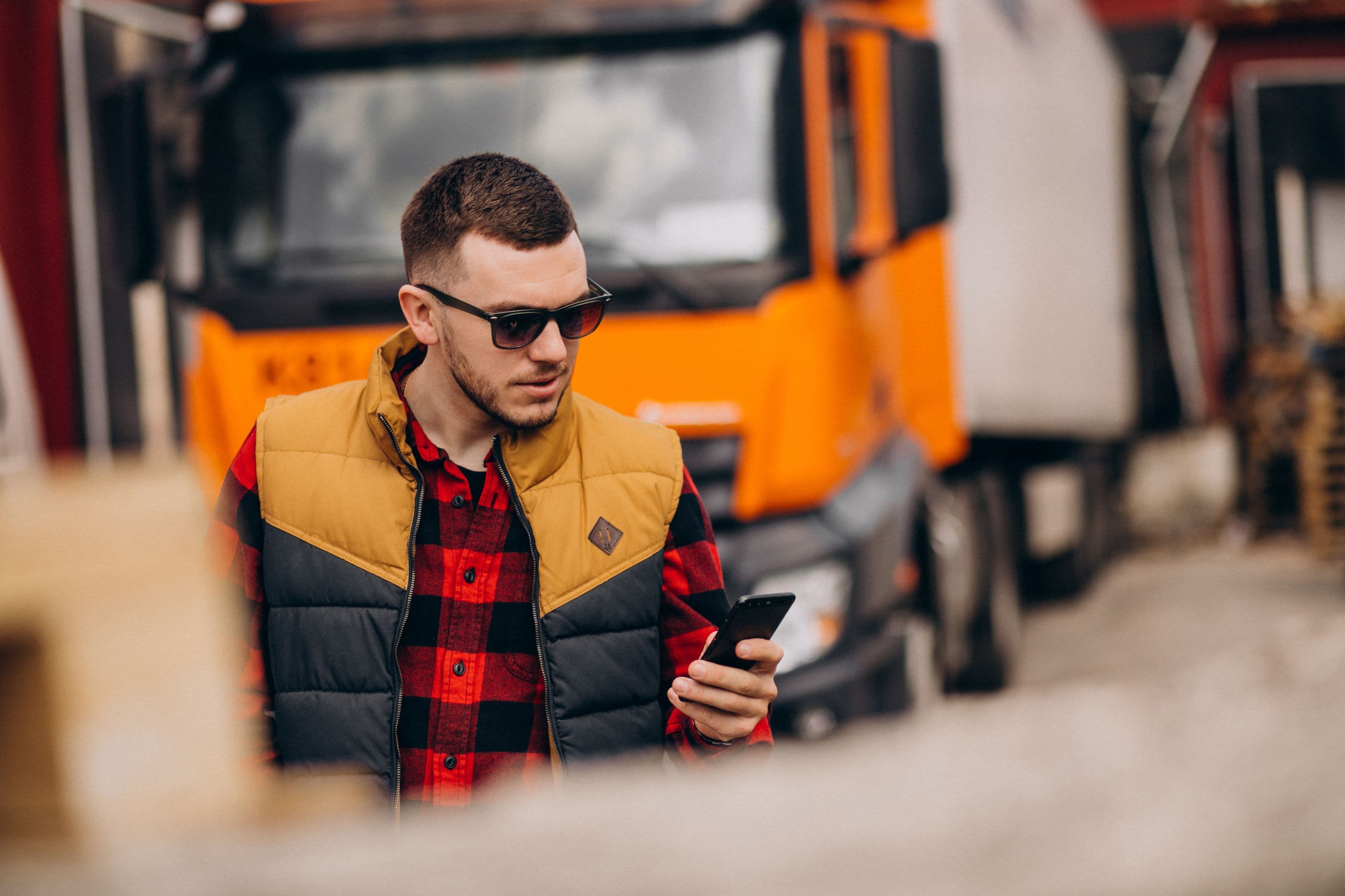 A person walking away from a HGV while using their phone