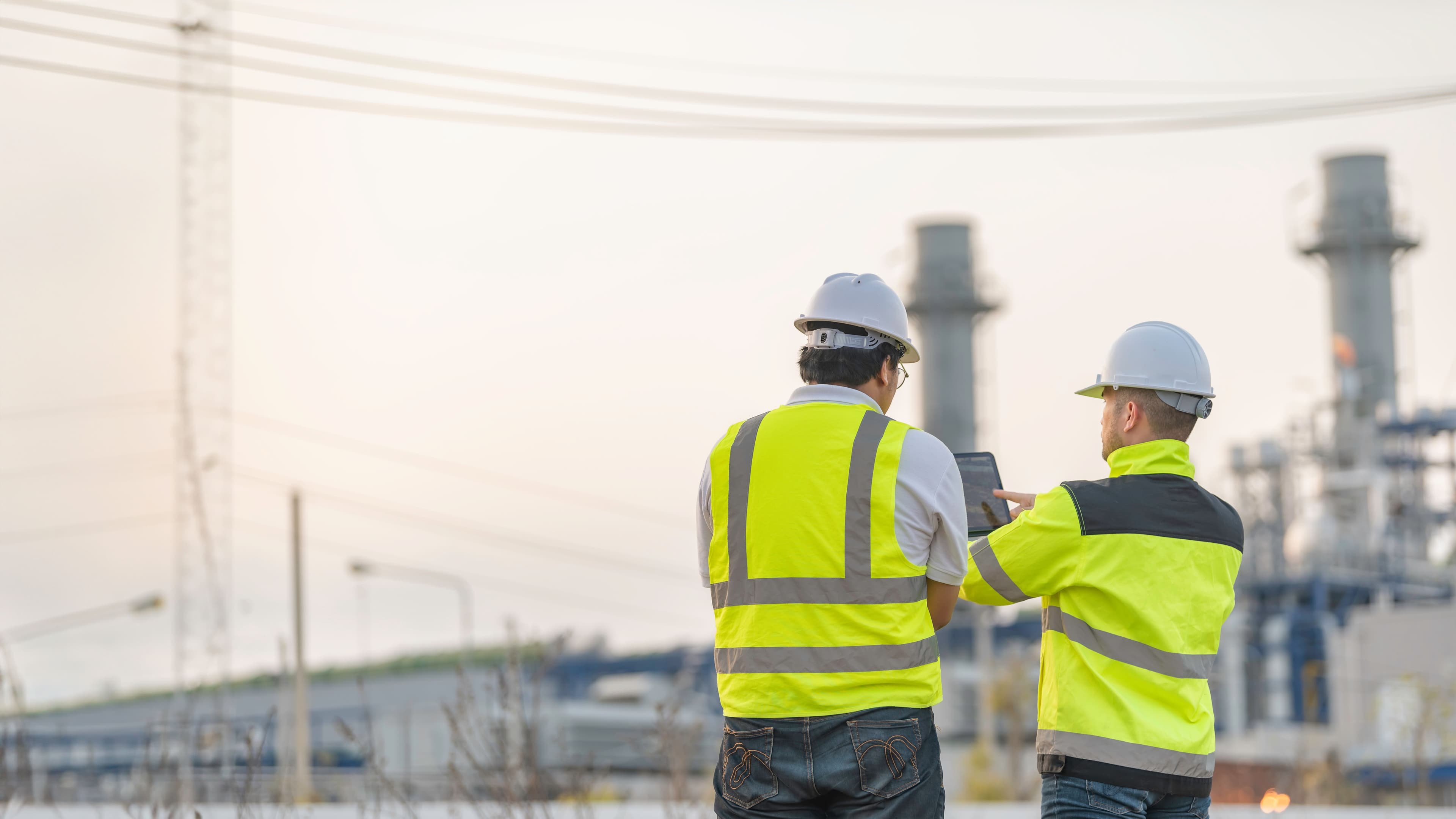Two people looking at a energy facility 
