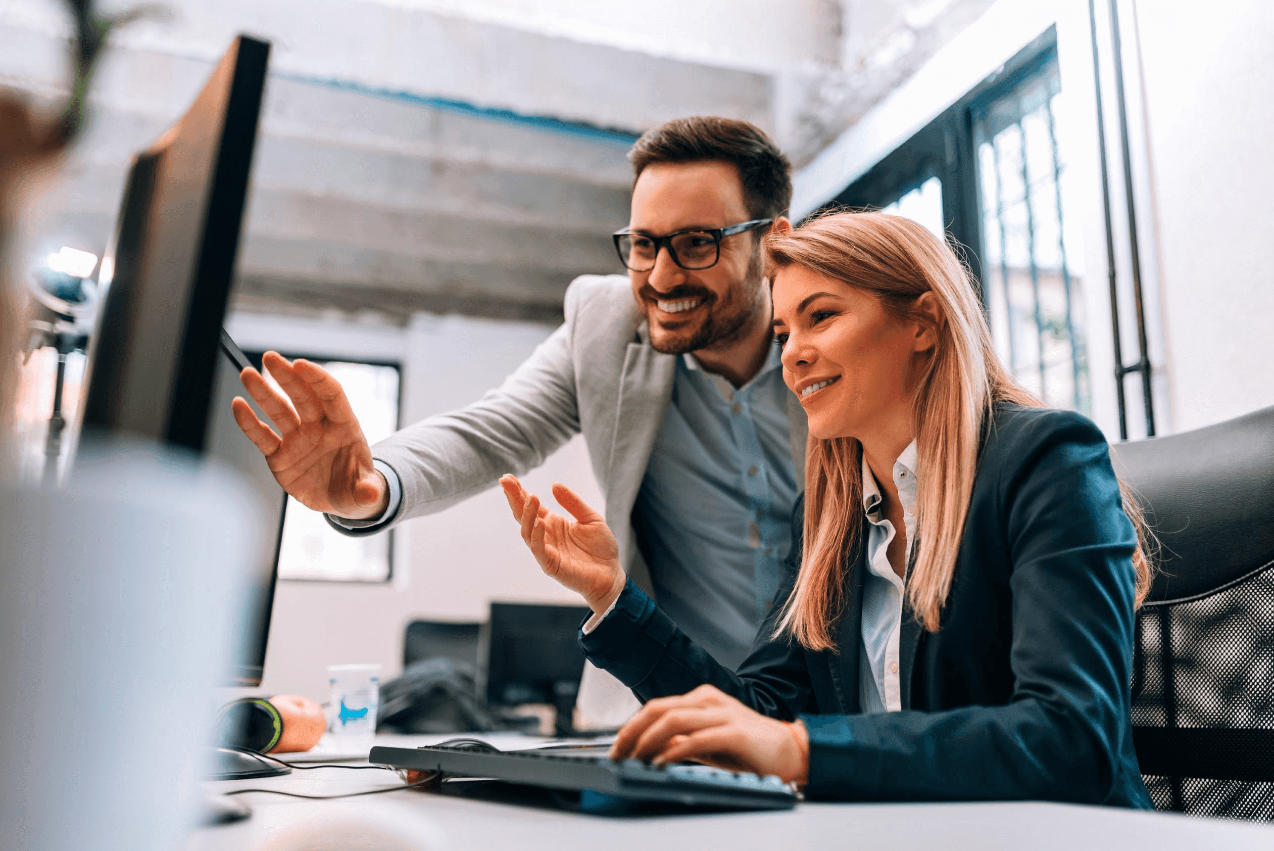 Two people having a meeting while looking at a monitor