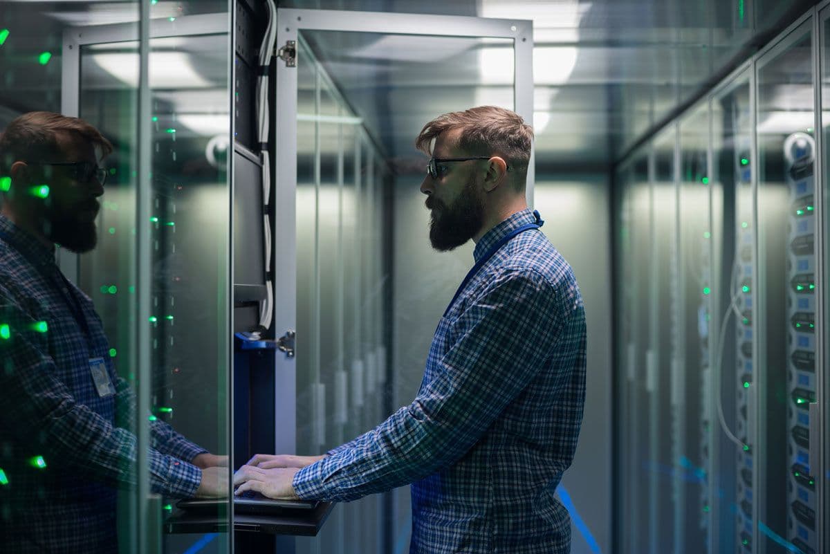 A person using a keyboard in a server room