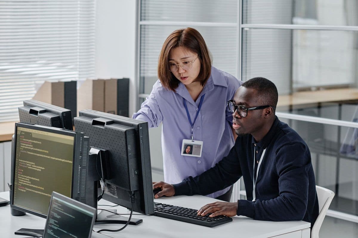 Two people having a meeting while looking at a monitor