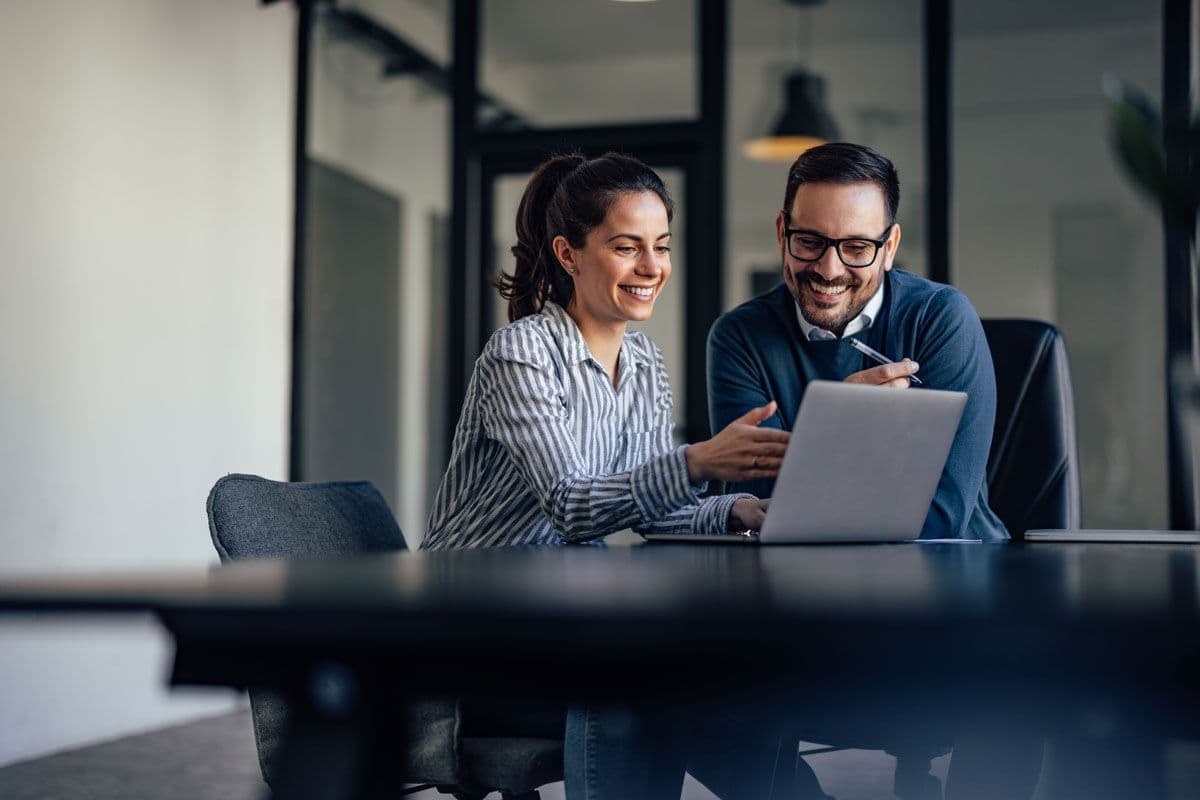 Two people having a meeting while using a laptop