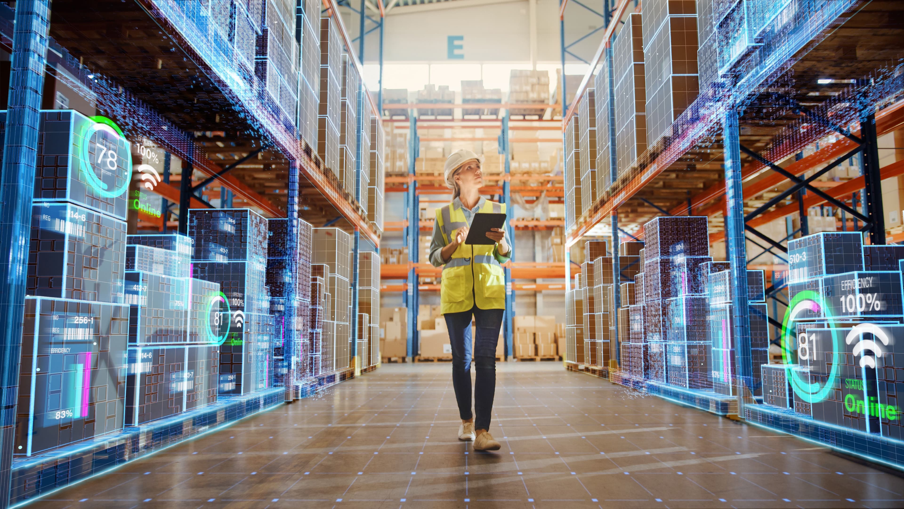 Female warehouse worker dressed in high vis, holding an ipad whilst looking at shelves of goods in a warehouse