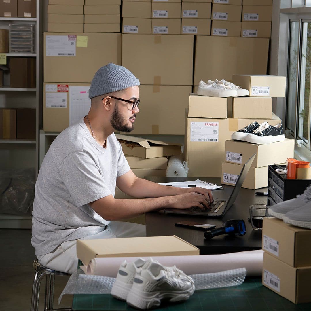 One person sat at a desk with lots of cardboard boxes around them