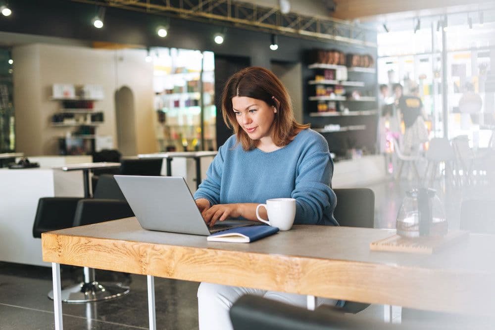 A person sat at a desk using a laptop