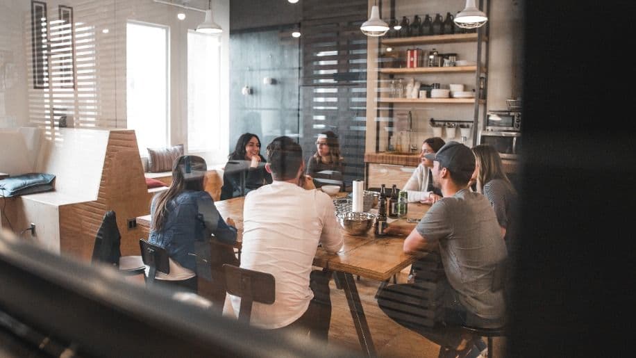 Multiple people sat around a table having a business meeting