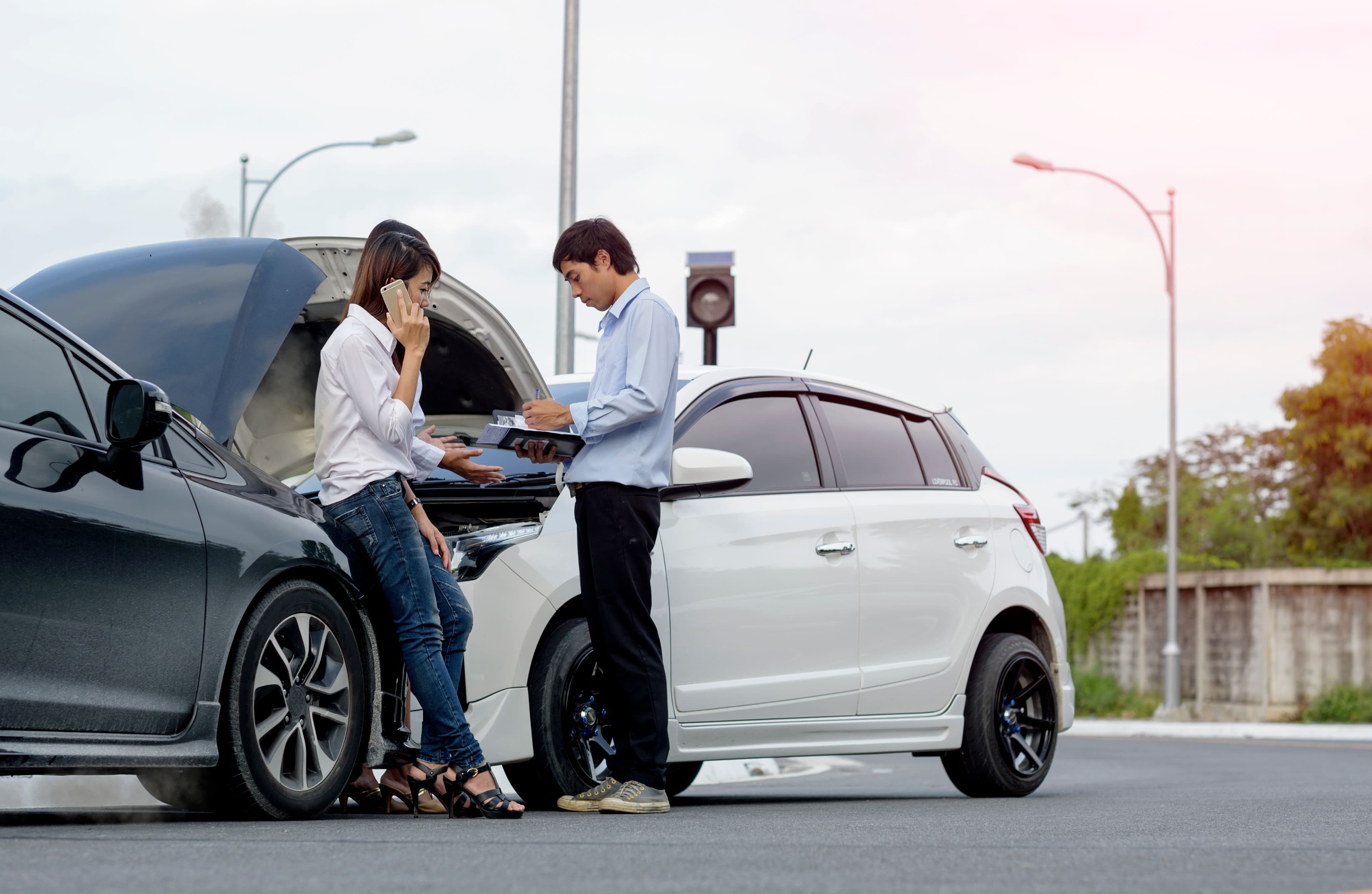 Two people exchanging insurance details after an accident