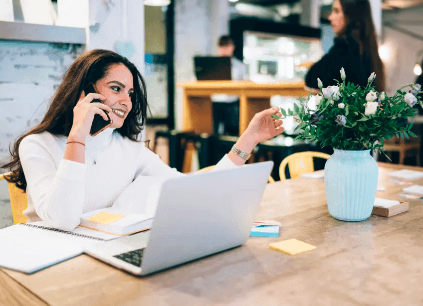 A person on the phone with their laptop open