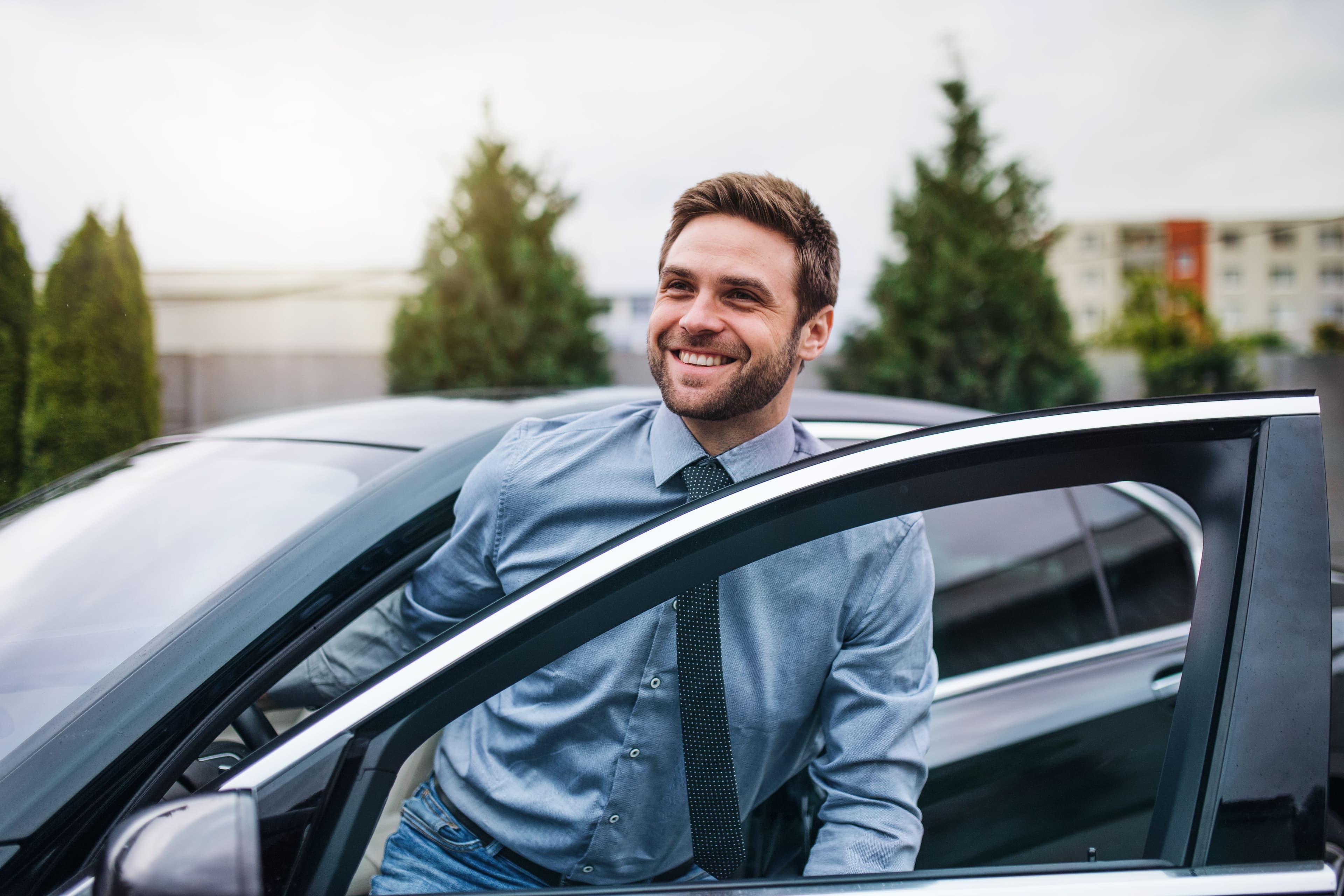 A businessperson getting into their car