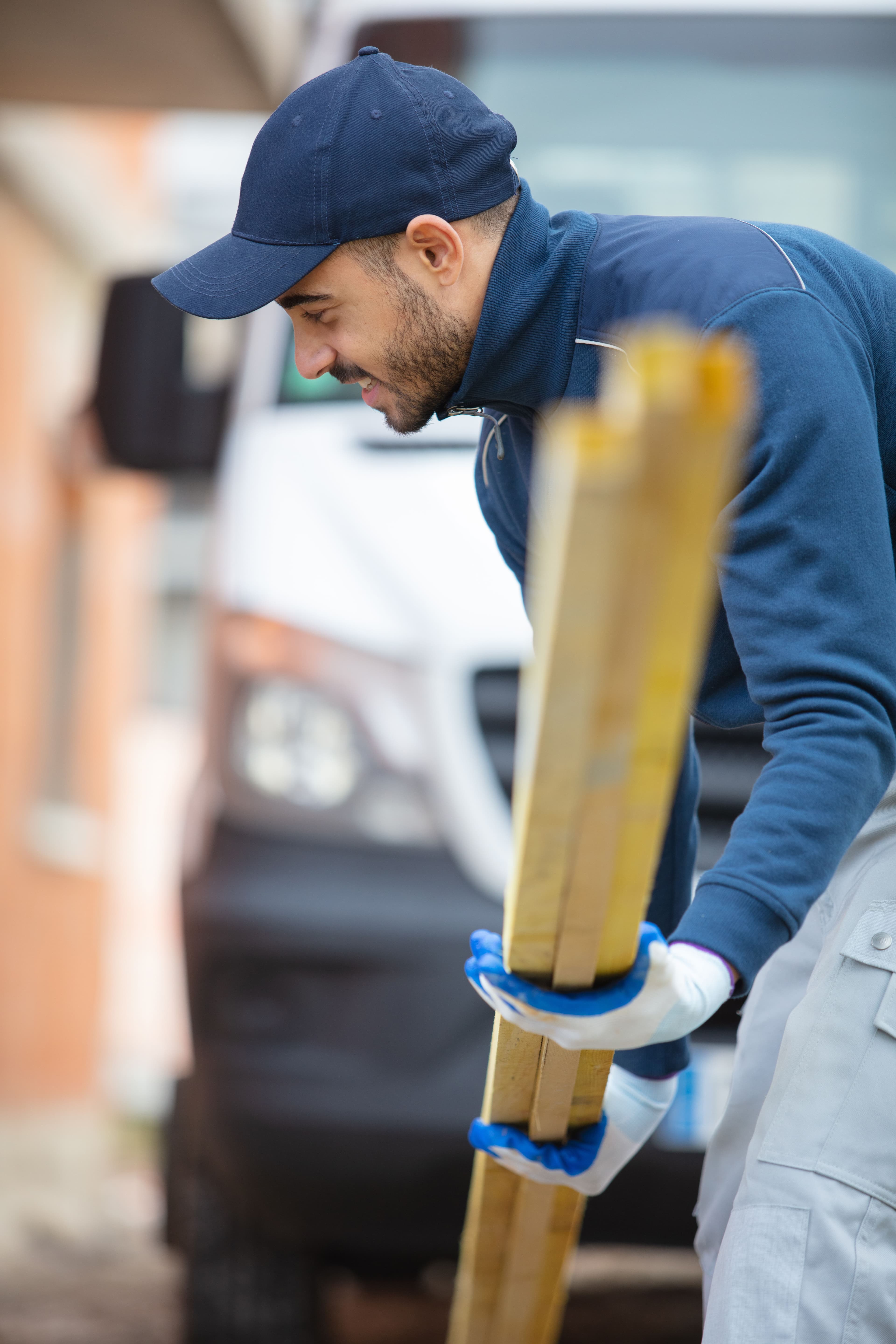 Tradesperson picking up yellow pipes from the ground