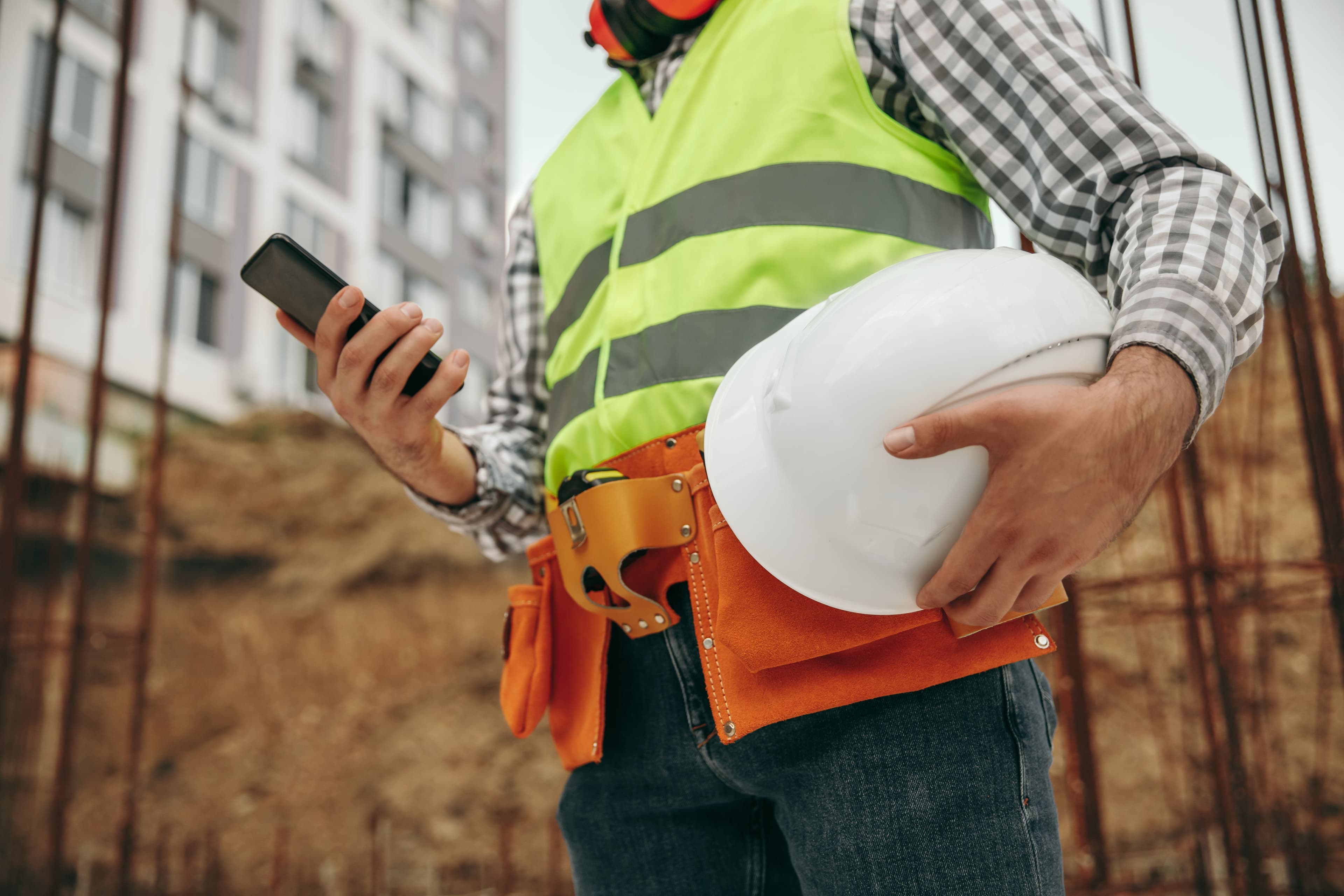 Male construction worker holding a mobile phone