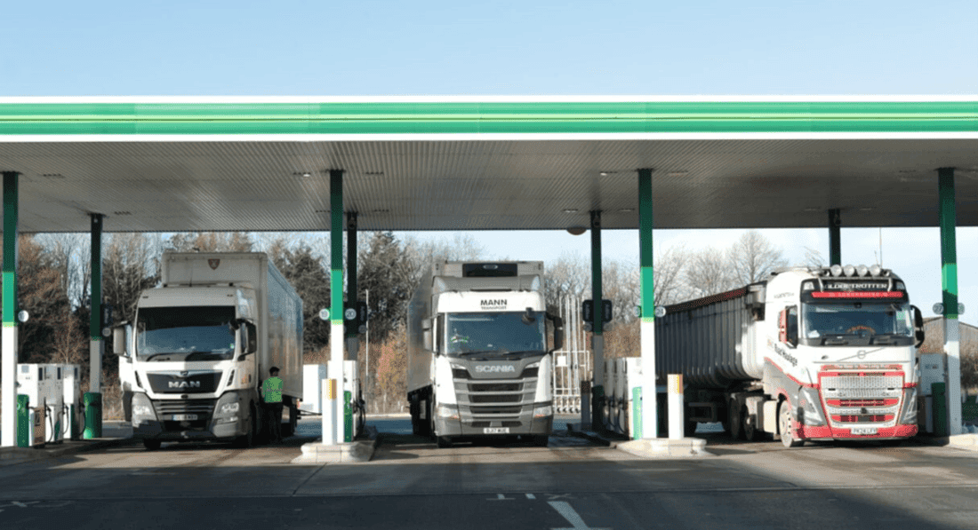 Three lorries fuelling up at MOTO services station in Rugby on a bright, sunny day