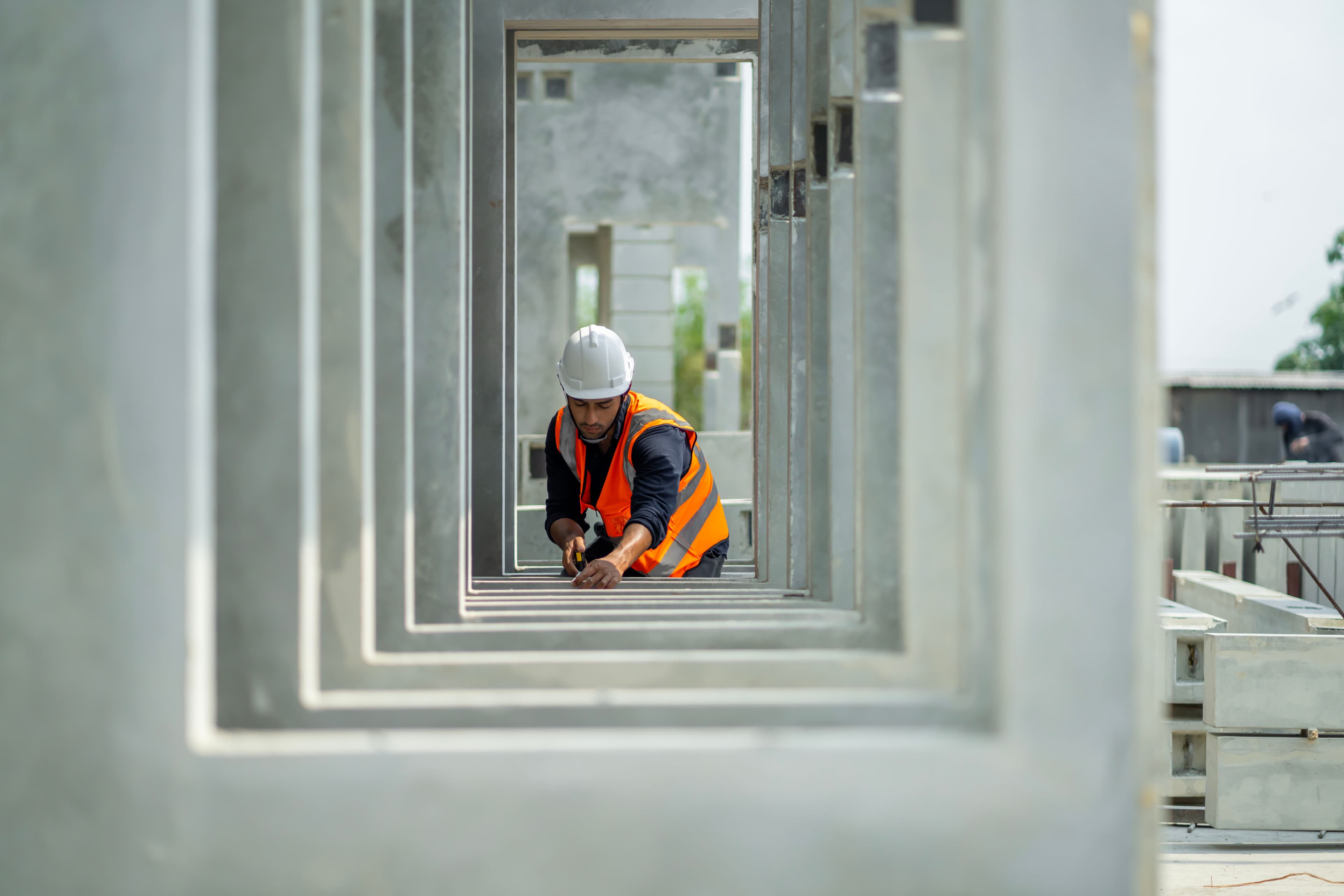 A person wearing a hard-hat and hi vis inspecting building work