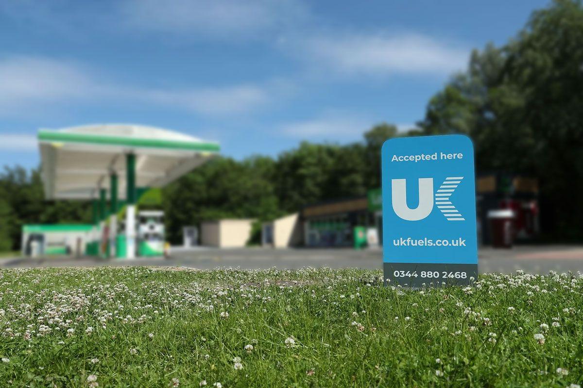 UK Fuels sign with petrol station in distance
