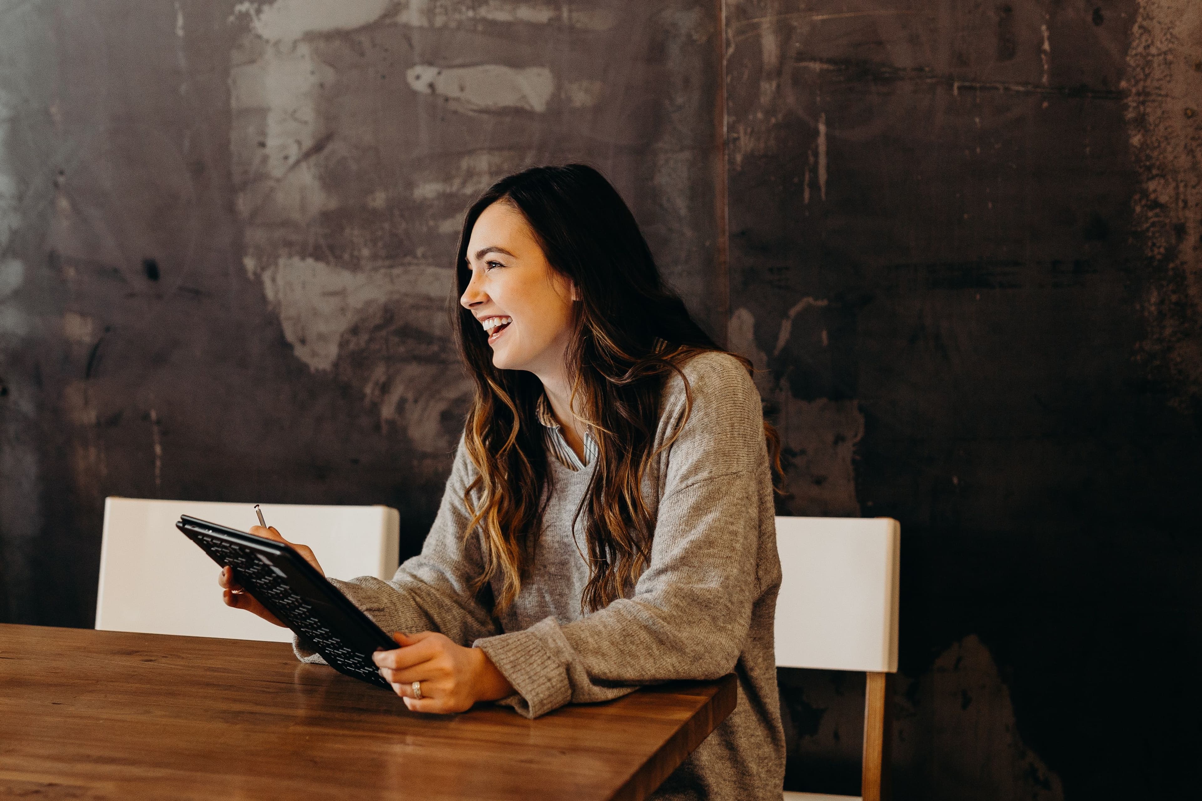 A person sat at a table using a tablet