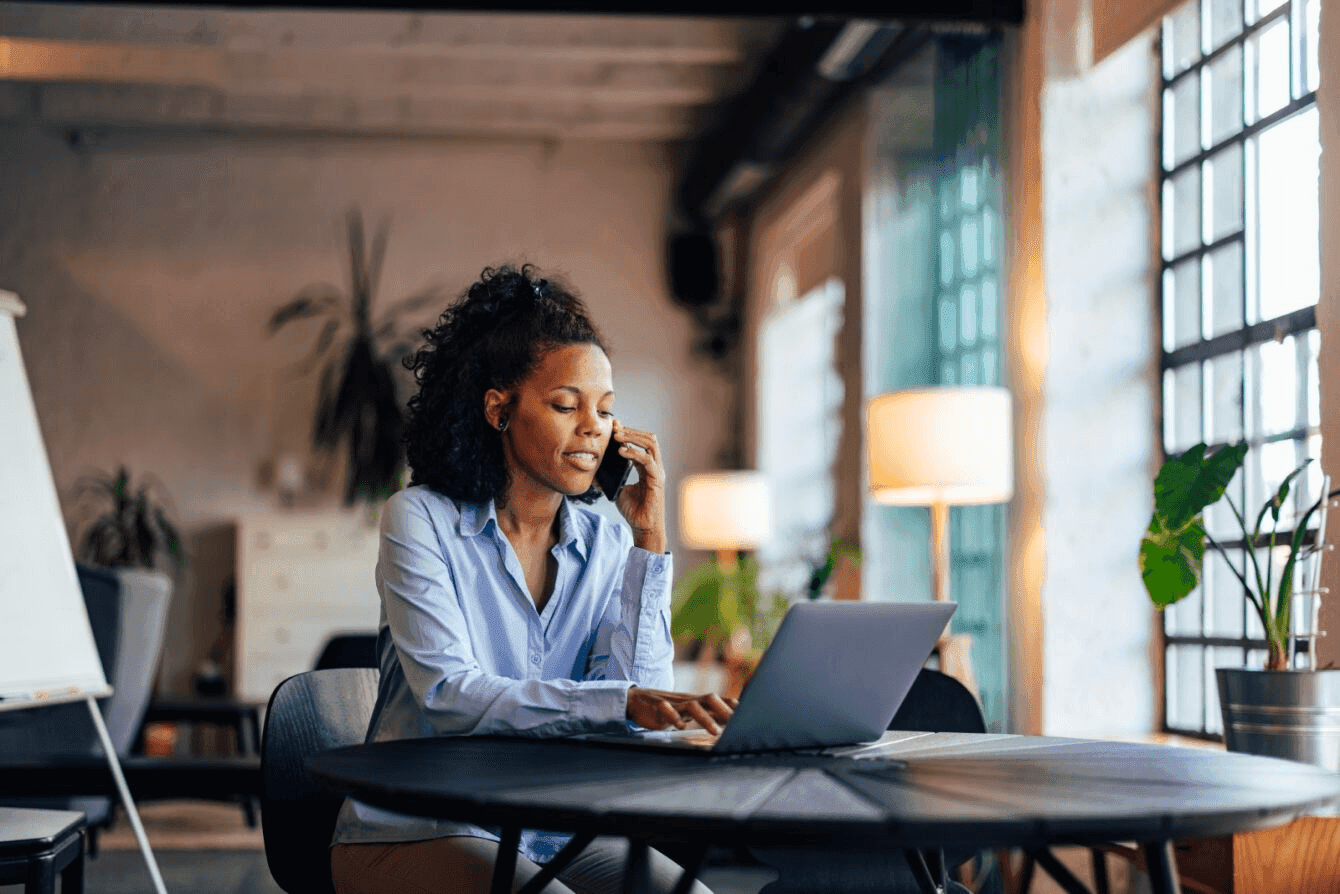 Person sitting at a table with their laptop open while on a call