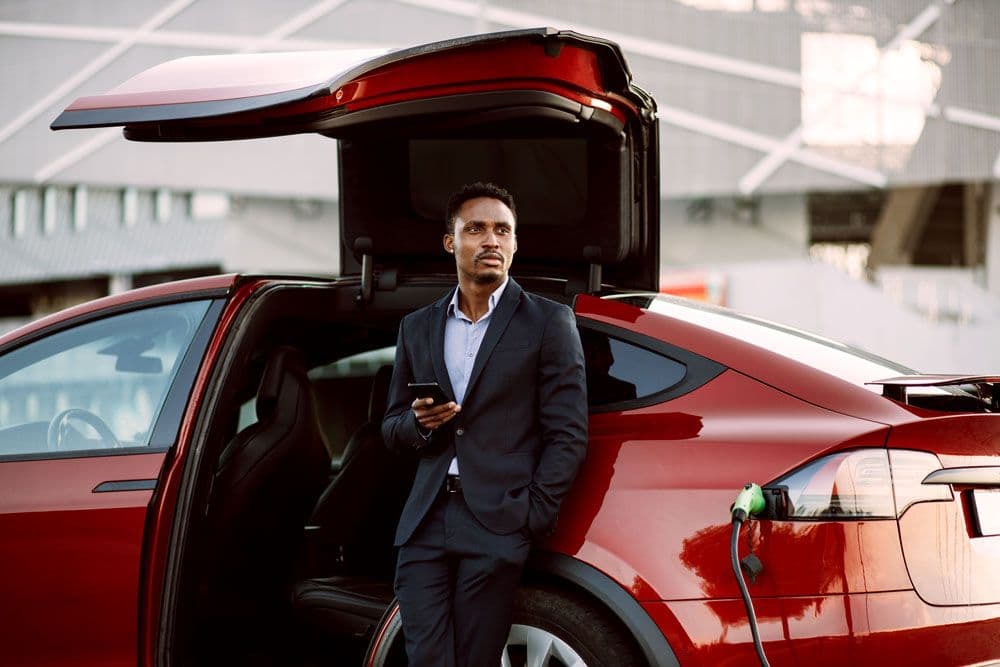 Someone standing beside a red electric vehicle