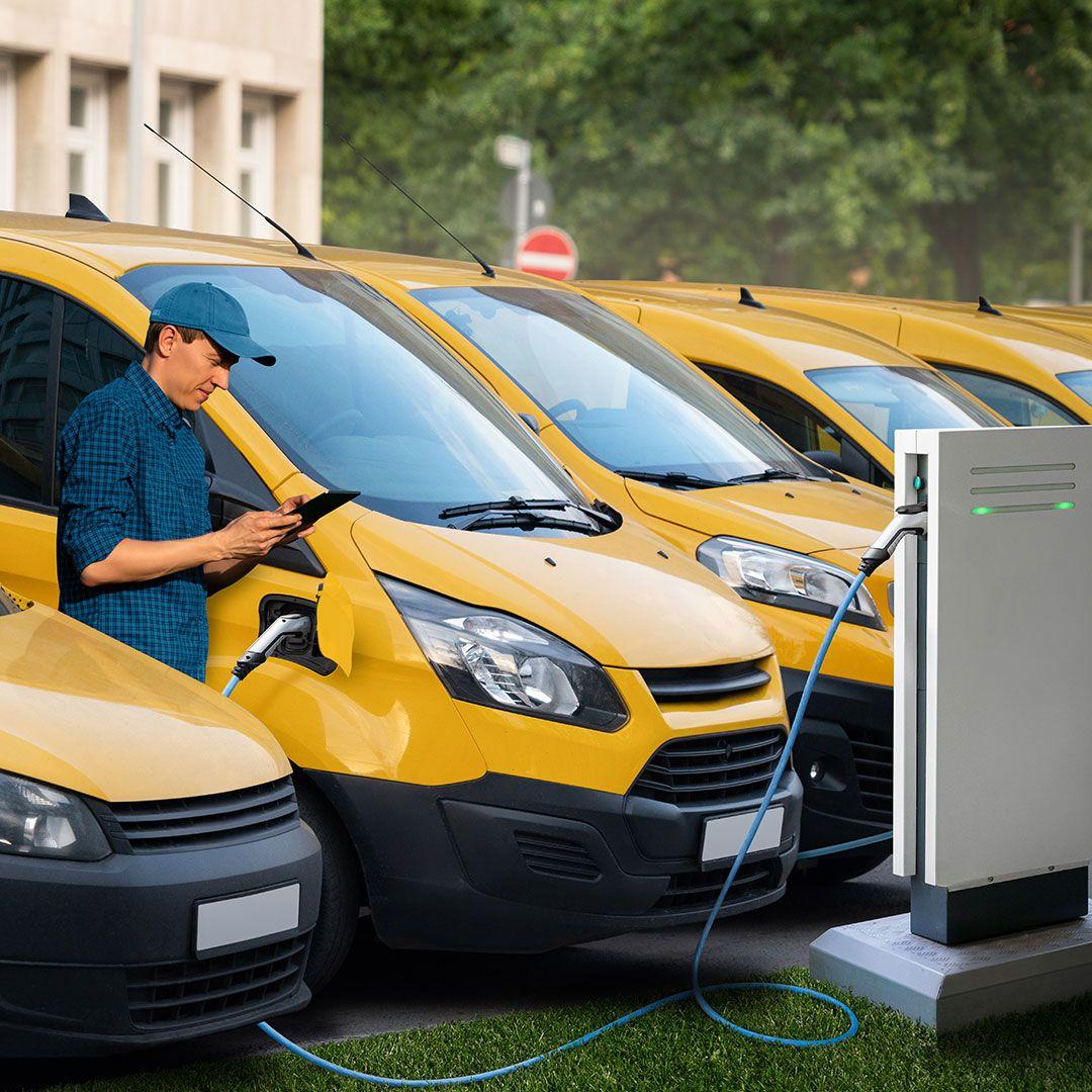 A line of parked electric vans on charge