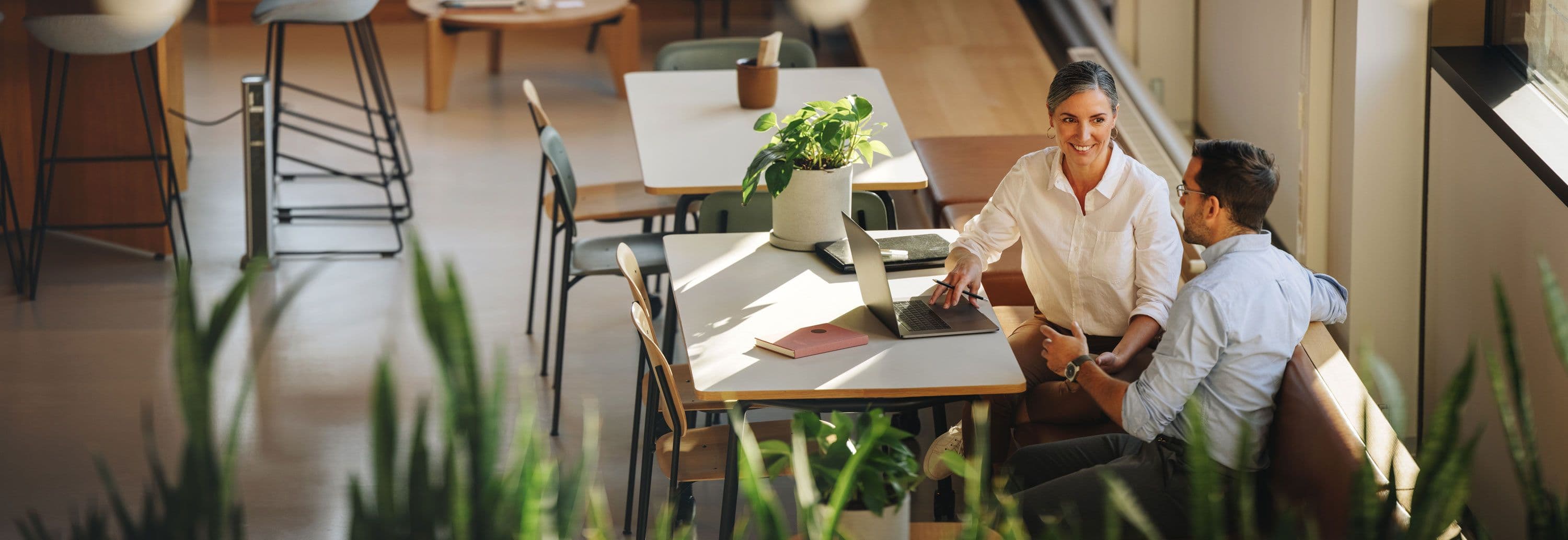 Two people sat at a desk having a business meeting