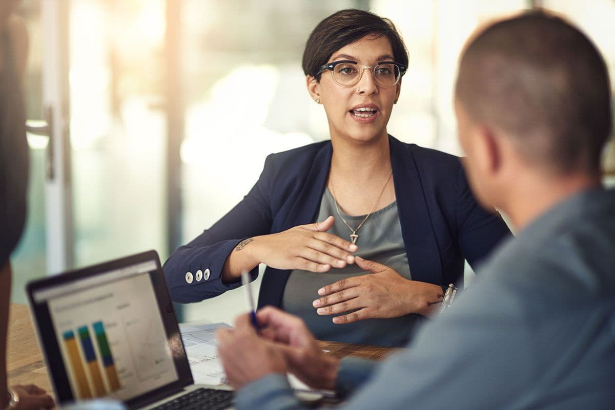 Two people having a business meeting while using a laptop