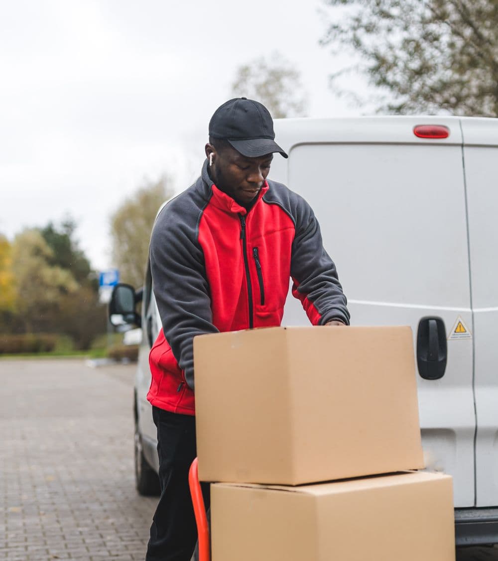 Courier driver transporting two boxes from their van