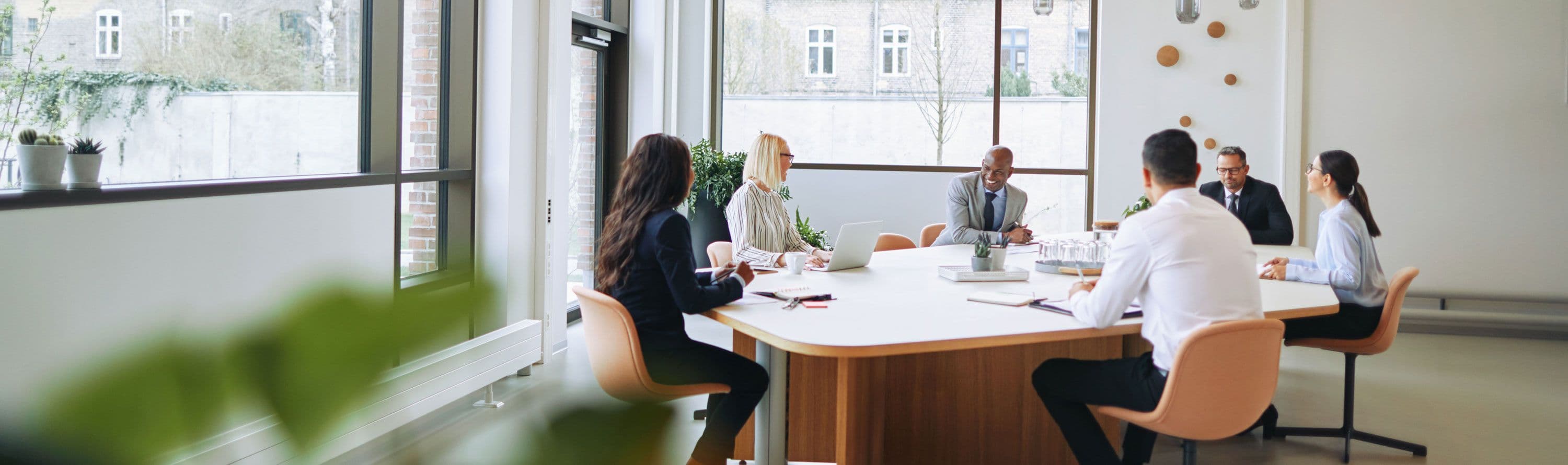 Six people sitting around a table having a business meeting