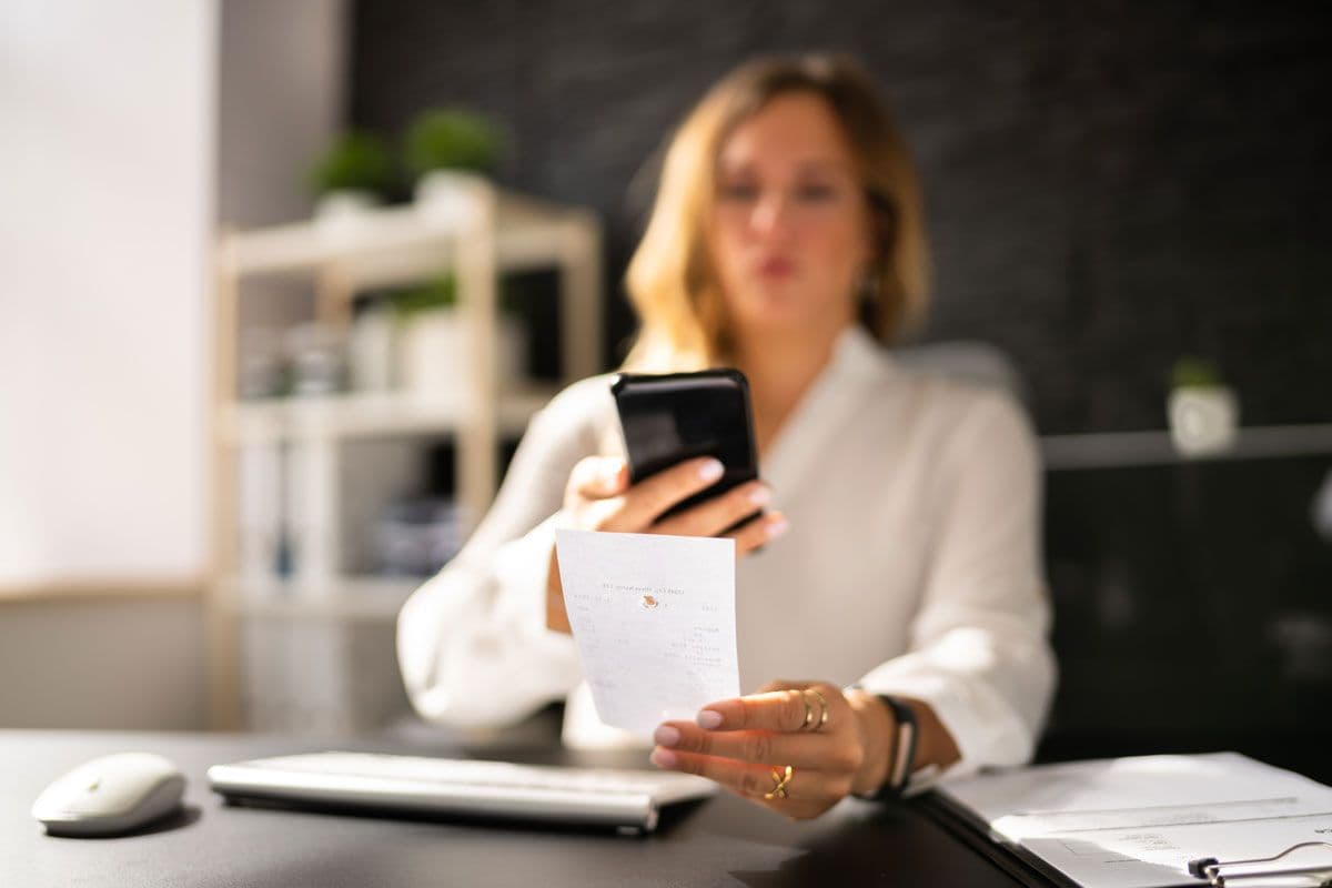 A person using a phone to scan a receipt