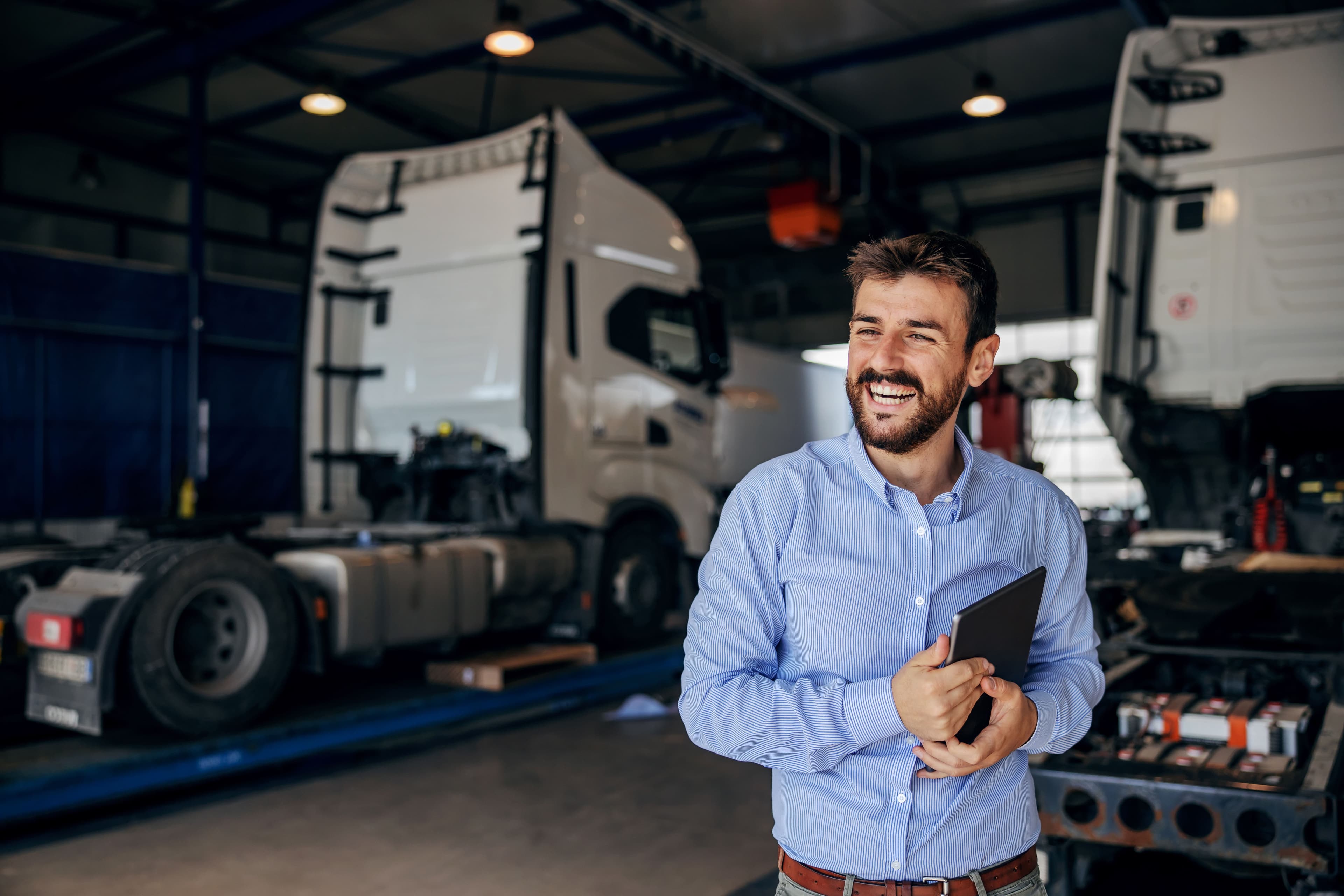 Someone holding a tablet in a truck garage