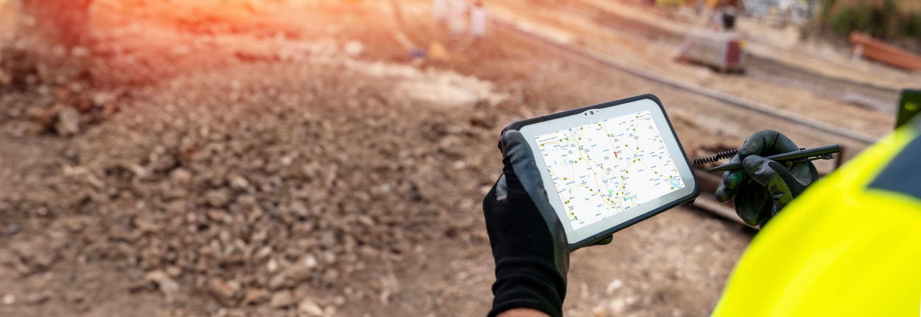 A person wearing a hi vis using a tablet