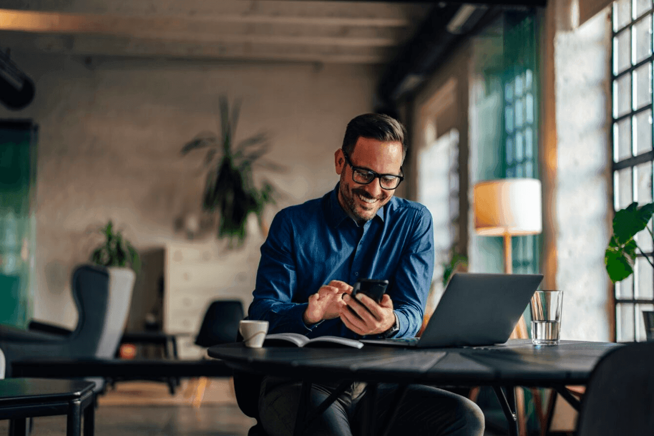 Business person on their phone sitting at a table